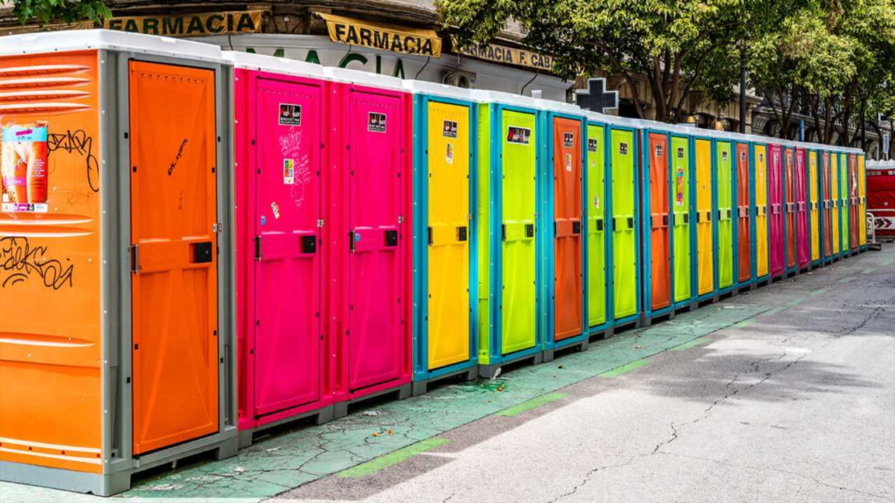 Eine Reihe an Plastikkabinen, die nebeneinanderstehen. Sie sind in bunten Neon-Farben gehalten.