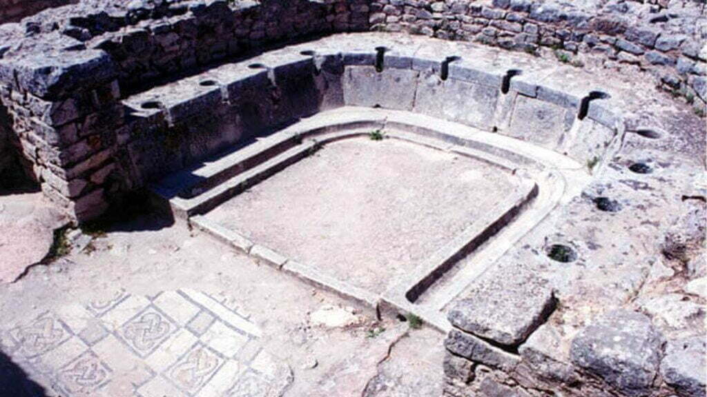 Eine alte, römische Latrine. Die "Sitzplätze" über den Löchern sind in einem Halbkreis angeordnet.