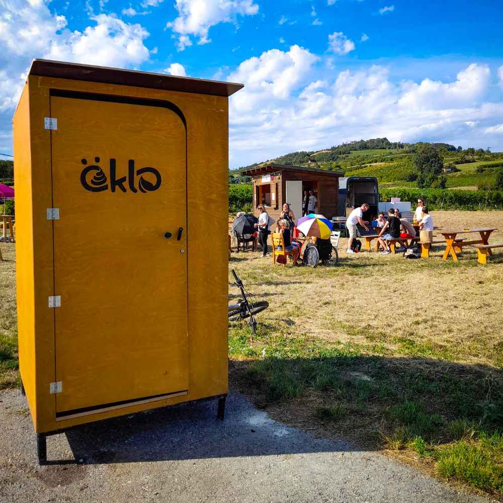 Holz-Campingtoilette von öKlo auf einem Campingplatz als nachhaltige Sanitärlösung ohne Wasseranschluss.